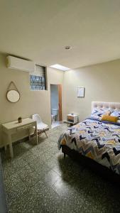 a bedroom with a bed and a table and a desk at Lindo espacio, cómodo y céntrico in San Salvador