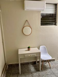 uma mesa e uma cadeira ao lado de uma parede com um espelho em Lindo espacio, cómodo y céntrico em San Salvador