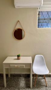 a table and a white chair next to a wall at Lindo espacio, cómodo y céntrico in San Salvador
