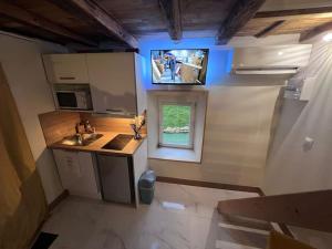 a small kitchen with a sink and a tv on the wall at Escale à Boinville in Prunay-le-Gillon