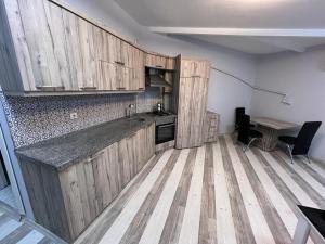 a kitchen with wooden cabinets and a wooden floor at Safir Suites & Apartment in Nilüfer