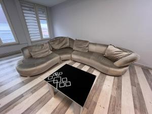 a brown leather couch in a living room with a rug at Safir Suites & Apartment in Nilüfer