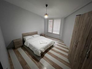 a white bedroom with a bed and a window at Safir Suites & Apartment in Nilüfer