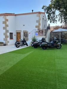 two motorcycles parked on a lawn in front of a house at PENSION ORUEIRO VILASERIO in Negreira