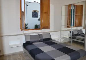 フィレンツェにあるResidenza Cavourのチェッカーベッド1台と窓が備わるベッドルーム1室が備わります。