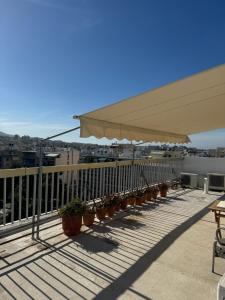 une rangée de plantes en pot sur un balcon dans l'établissement George, à Athènes