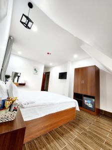 ein Schlafzimmer mit einem großen Bett und einem TV in der Unterkunft Happy Bun Hotel Da Lat in Da Lat