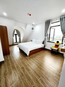 Schlafzimmer mit einem Bett und Holzboden in der Unterkunft Happy Bun Hotel Da Lat in Da Lat