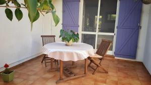 a table with two chairs and a potted plant on it at les deux pins in Saintes-Maries-de-la-Mer