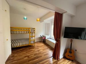 Un dormitorio con una cama y una guitarra en una habitación. en Family friendly downtown apart, en Sofía