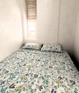 a bed with a floral comforter in a bedroom at Catherine Suites in Willemstad