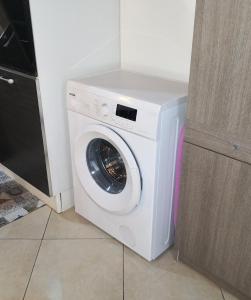 a white washing machine in a kitchen next to a door at A viuzza in Cefalù