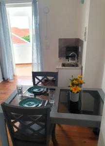 cocina con mesa, 2 sillas y lavamanos en Catherine Suites, en Willemstad