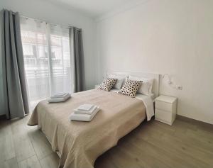 Casa Antonio - apartamento Orion في بلايا دي سان خوان: غرفة نوم بسرير كبير عليها منشفتين