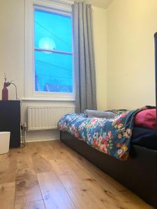 Schlafzimmer mit einem Bett und einem Fenster in der Unterkunft Ilford Tiny Jewel in Ilford