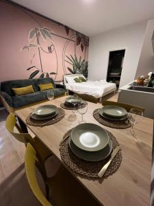a living room with a table with plates on it at Calari Rooms - Monolocale in Bologna