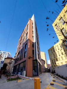 a tall building with birds flying in the sky at Doraci apartments in Tirana