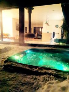 a swimming pool with blue lights in a house at Aurora View Lapland, Sky View Bedroom & Jacuzzi in Kilpisjärvi