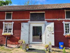 een rood-wit huis met een witte deur bij Marmorcafets B&B in Kolmården