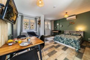 Una habitación con mesa de comedor y un dormitorio. en Le Grand Colibri, en Saint-Denis