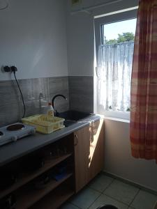 a kitchen with a sink and a window at Domki letniskowe Aneta in Trzęsacz