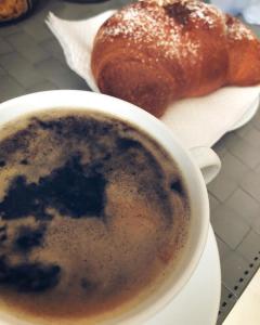 eine Tasse Kaffee und ein Gebäck auf dem Tisch in der Unterkunft La Stella Di Napoli B&B in Neapel