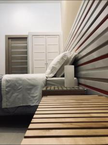 sypialnia z łóżkiem ze ścianą w paski w obiekcie La Stella Di Napoli B&B w mieście Neapol
