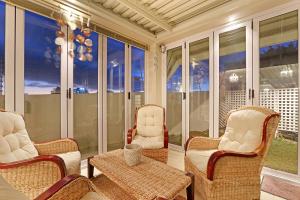 un porche cubierto con sillas y mesa en Bayview 30 by HostAgents, en Bloubergstrand