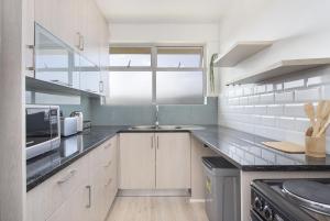 a kitchen with a sink and a microwave at Blouberg Heights 207 in Bloubergstrand