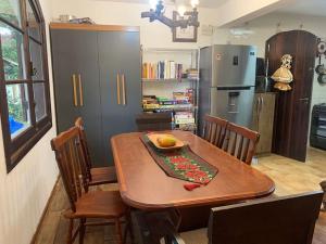 a kitchen with a table and chairs and a refrigerator at Casa Aconchegante em Monte Verde in Camanducaia