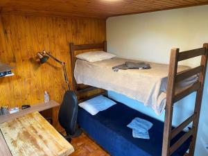 um beliche num quarto com uma secretária e uma cama sidx sidx em Casa Aconchegante em Monte Verde em Camanducaia