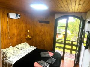 Habitación con cama en habitación con ventana en Casa Aconchegante em Monte Verde en Camanducaia