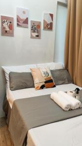 een bed met kussens in een kamer bij Anuva Stays in Manilla