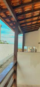 a building with a wooden roof and a bench at Casa simples de frente para praia 5km do centro in Saquarema