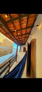 einen Balkon mit einer blauen Hängematte in einem Gebäude in der Unterkunft Casa simples de frente para praia 5km do centro in Saquarema
