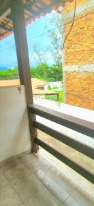 a balcony with a bench and a brick wall at Casa simples de frente para praia 5km do centro in Saquarema
