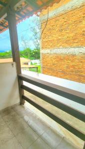 a building with a brick wall and a bench at Casa simples de frente para praia 5km do centro in Saquarema