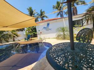 - une table avec un parasol à côté de la piscine dans l'établissement Casa Guadalupe, à Sipacate
