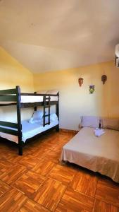 a bedroom with two bunk beds and a wooden floor at Casa Guadalupe in Sipacate
