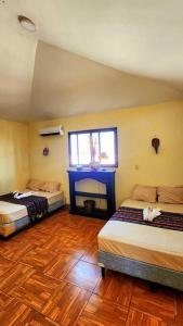 a room with two beds and a fireplace in it at Casa Guadalupe in Sipacate