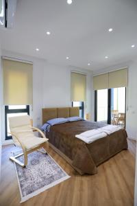 a bedroom with a large bed and a chair at Doraci apartments in Tirana