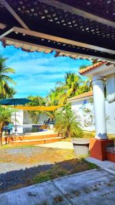- une vue sur une maison avec un parasol et des palmiers dans l'établissement Casa Guadalupe, à Sipacate