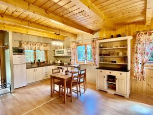 a kitchen with wooden ceilings and a table and chairs at Amalka Wita in Sulęczyno