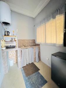 a kitchen with white walls and a sink and towels at De Paris à Conakry NONGO in Conakry