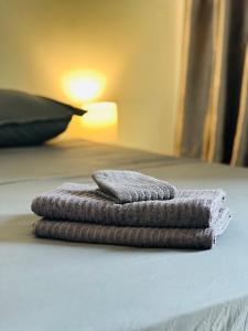 una pila de toallas sentadas encima de una cama en De Paris à Conakry NONGO, en Conakry
