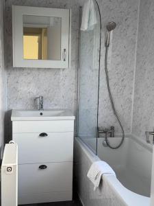 a white bathroom with a sink and a shower at 4 Bed House, Glenrothes sleeps 5 in Fife