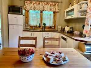a kitchen with a table with a bowl of strawberries on it at Amalka Wita in Sulęczyno +58 photos