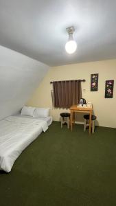 1 dormitorio con 1 cama y 1 mesa con teléfono en Villa Kolah Watu en Wonosobo