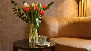 a vase of flowers on a table next to a chair at 286 Piazza San Marco in Venice