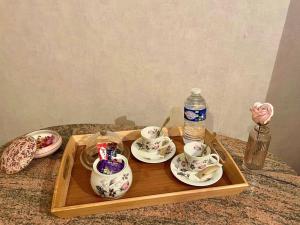 a tray with tea cups and a bottle of water at Le moulin de la Vernoelle in Prémilhat